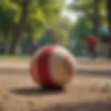 A vibrant hacky sack flying through the air in a park setting.