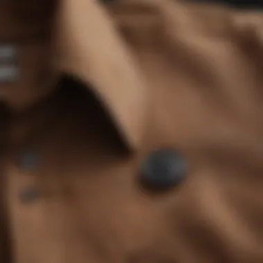 Close-up of the fabric texture and buttons of a brown long sleeve button-up shirt.