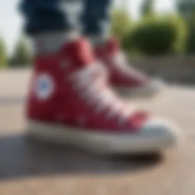 Burgundy high top Converse shoes on a skateboard at a park