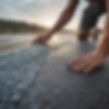 Surfer applying Dakine traction pad to a surfboard