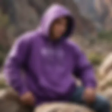 A vibrant purple Backwoods Hoodie draped over rocky terrain, showcasing its outdoor compatibility.