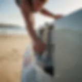 A surfer securing a key in a lock box on the beach