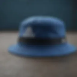 A stylish blue Adidas bucket hat placed on a textured surface