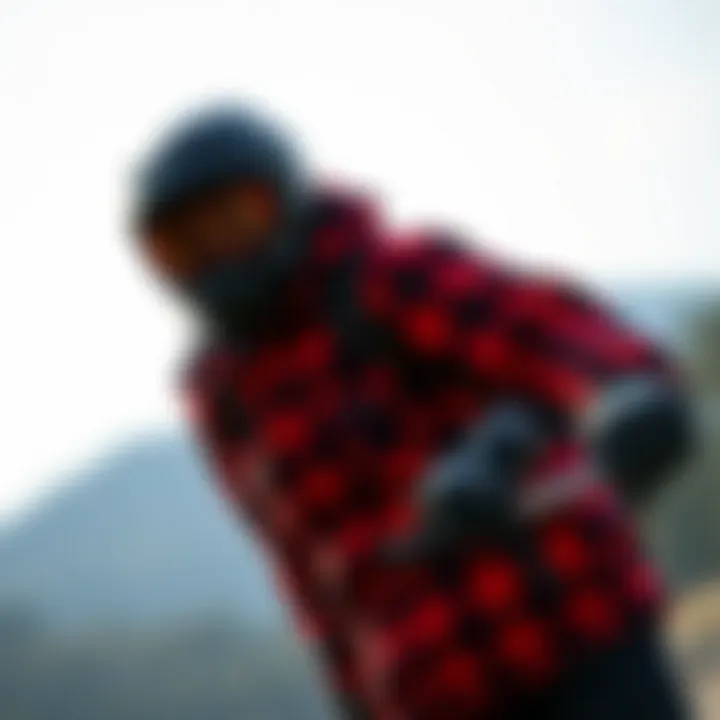 An individual wearing a red and black plaid jacket while engaged in an outdoor sport.