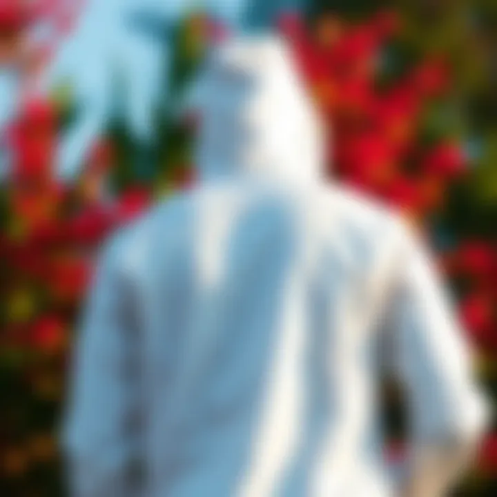 Pristine White Windbreaker in Nature A pristine white hooded windbreaker displayed against a vibrant outdoor backdrop